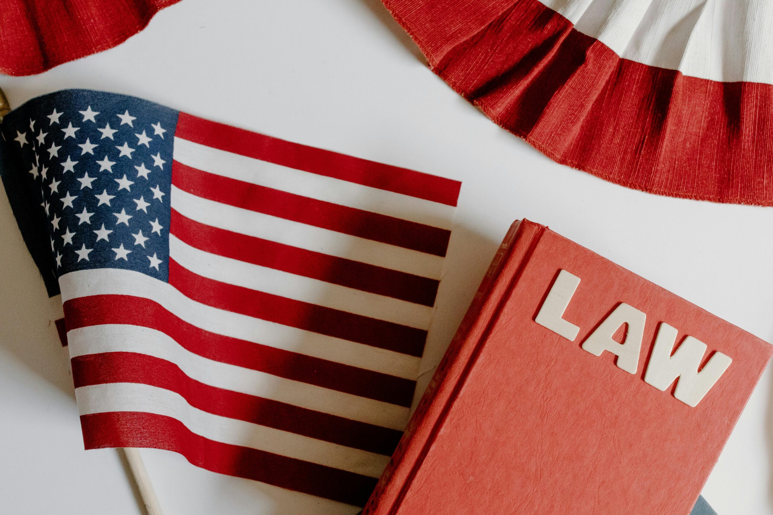 Patriotic scene with American flag and law book on a white background, symbolizing freedom and democracy.
